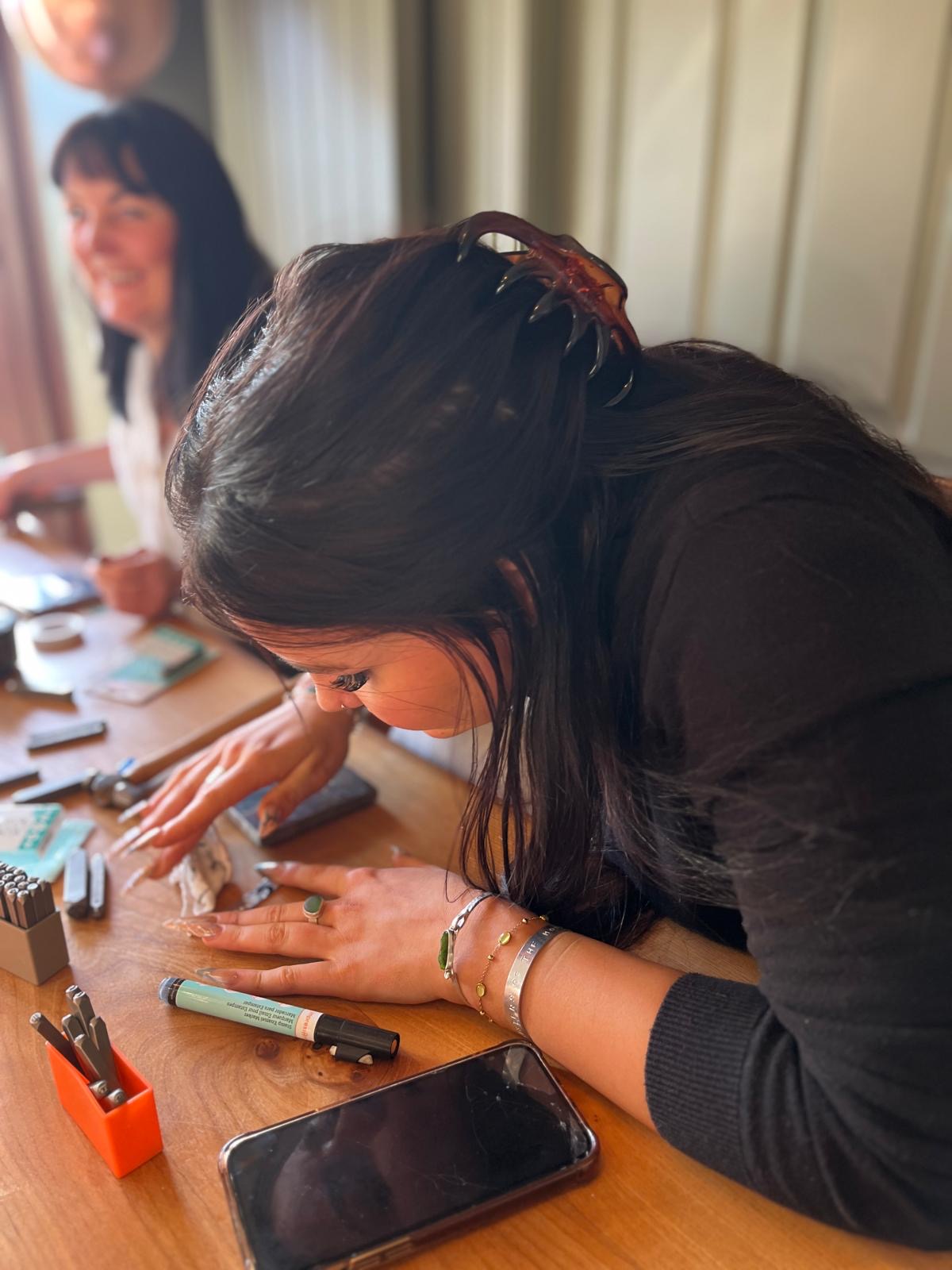 A participant focused on crafting a piece of handmade jewellery